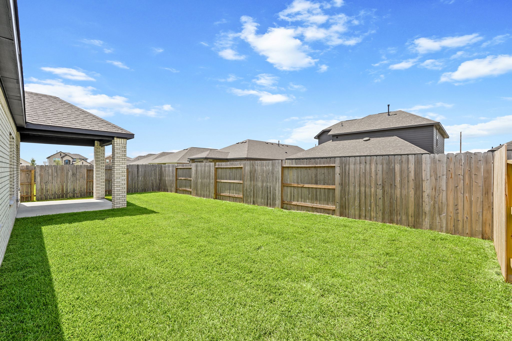 A fenced in yard with a house in the background.