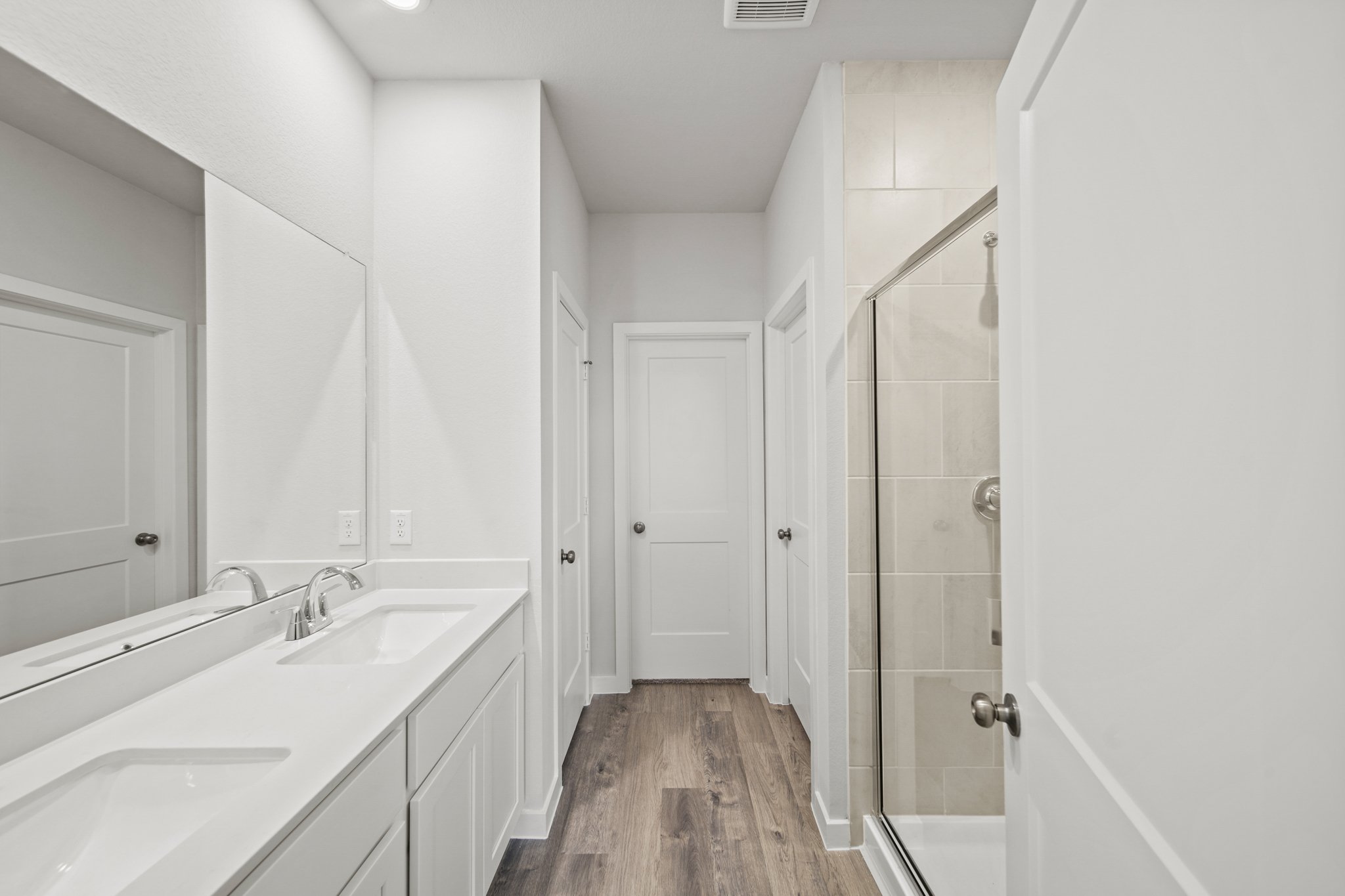 A bathroom with white cabinets.