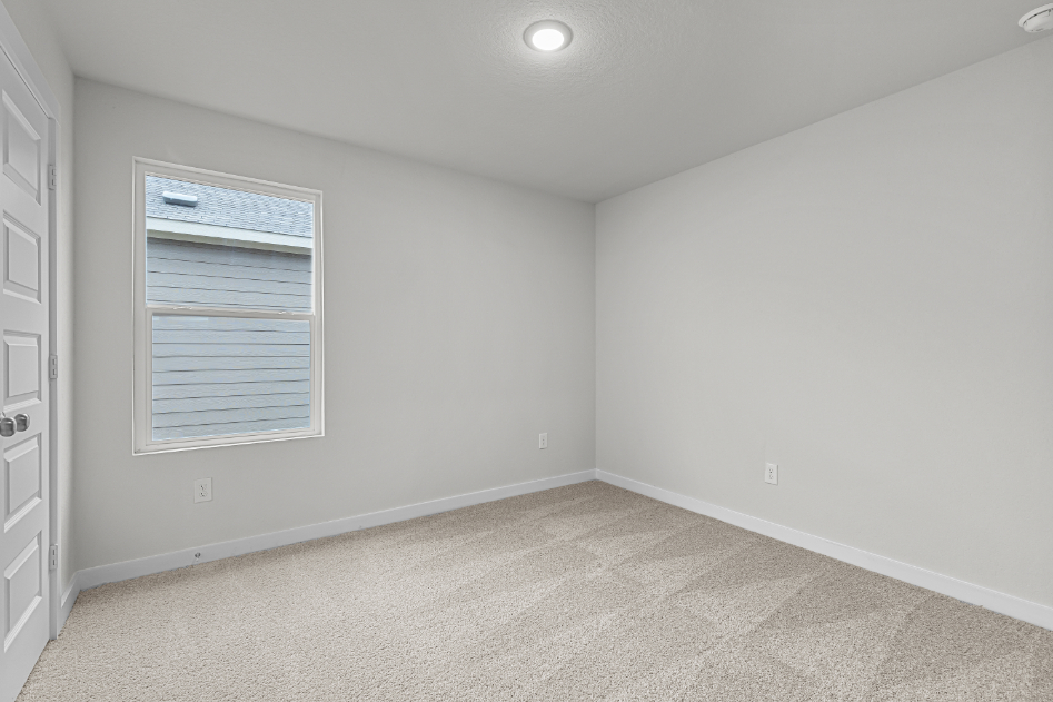 A room with a window and a carpet.