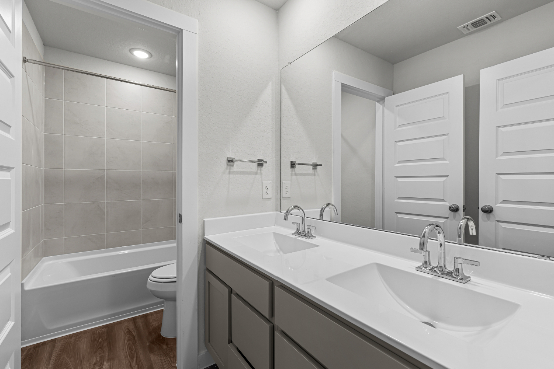 A bathroom with a tub sink and toilet.