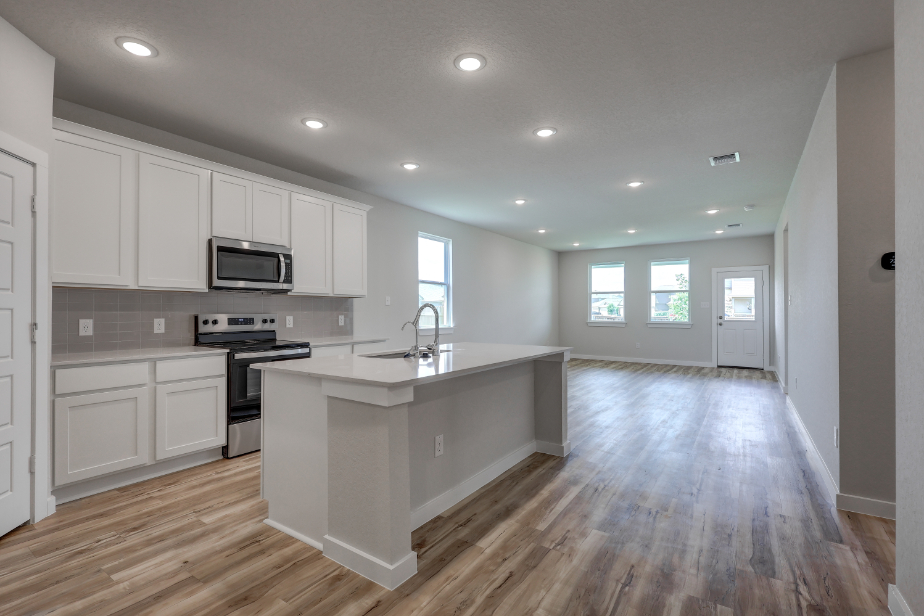 A kitchen with white cabinets.