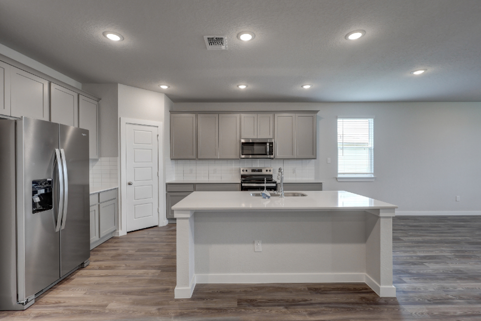 A kitchen with white cabinets.