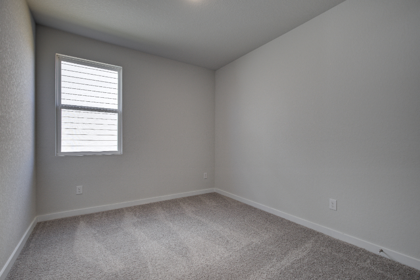 A room with a window and a carpet.
