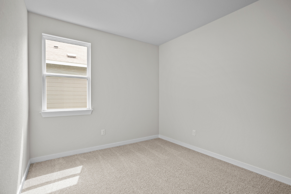 A room with a window and carpet.