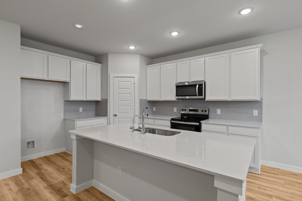 A kitchen with white cabinets.