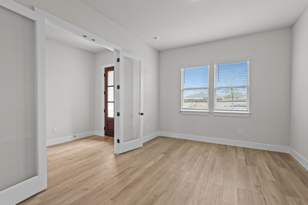 A room with a wood floor and white walls.
