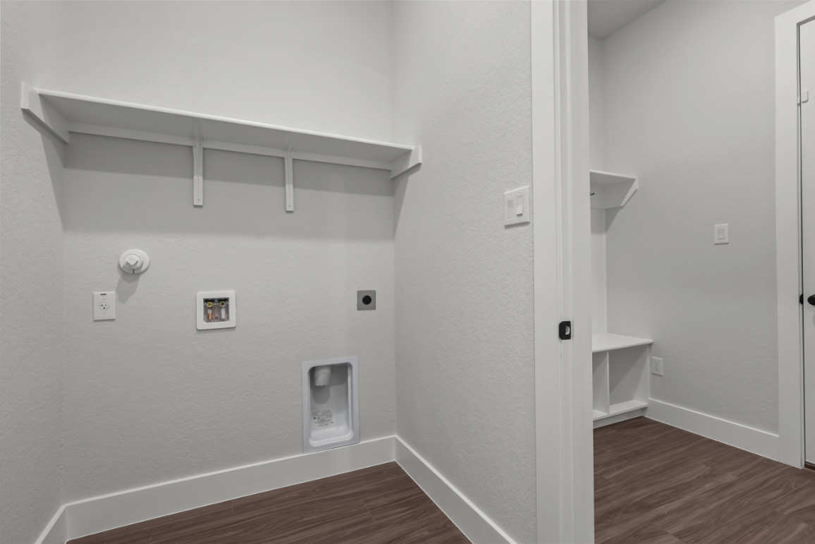 A white room with a wood floor and a white wall with a white door and a wood floor.