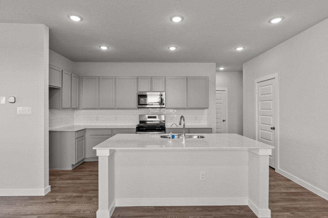 A kitchen with white cabinets.