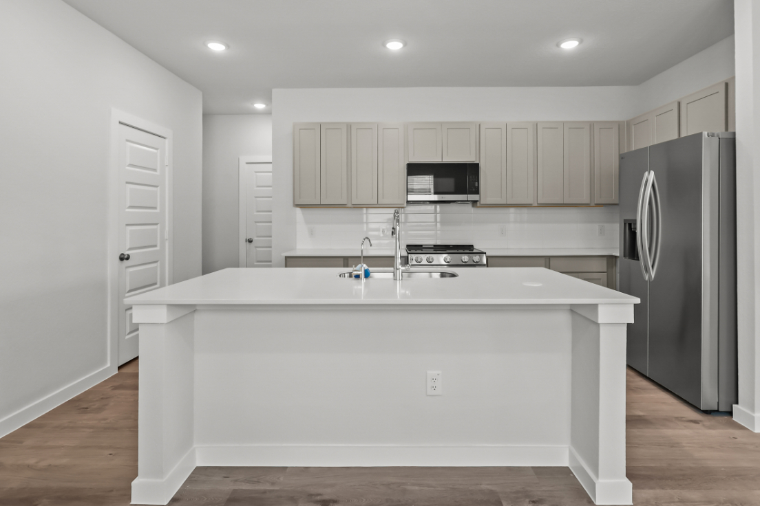 A kitchen with white cabinets.