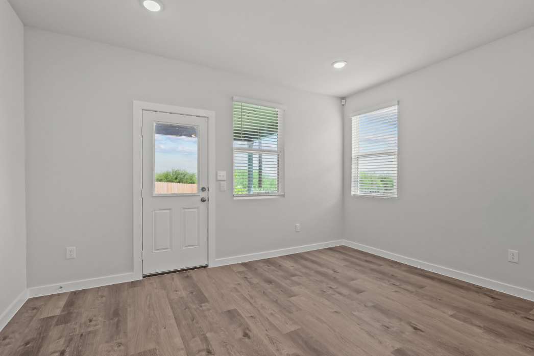 A room with a wood floor and a white door with windows.