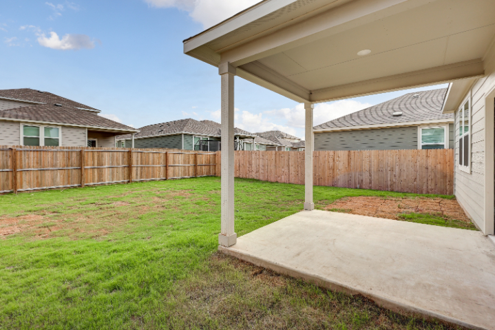 A backyard with a fence and a wood fence.