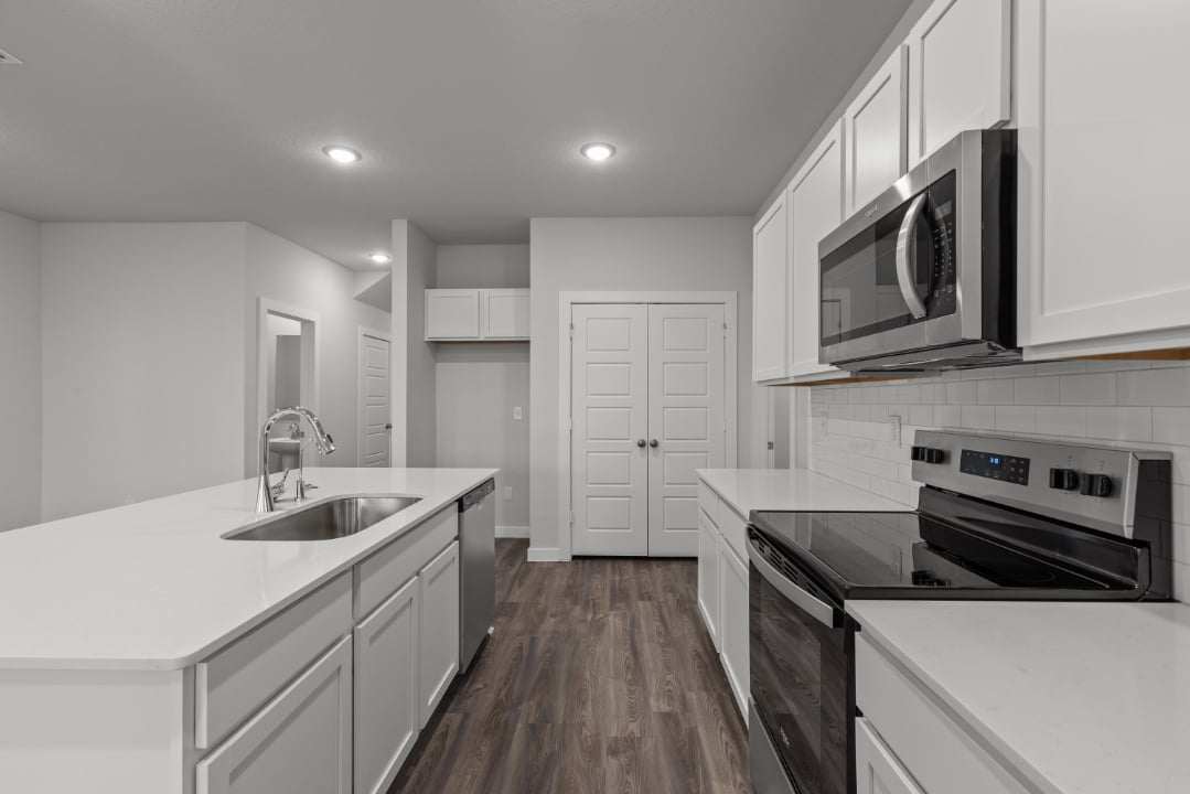 A kitchen with white cabinets.