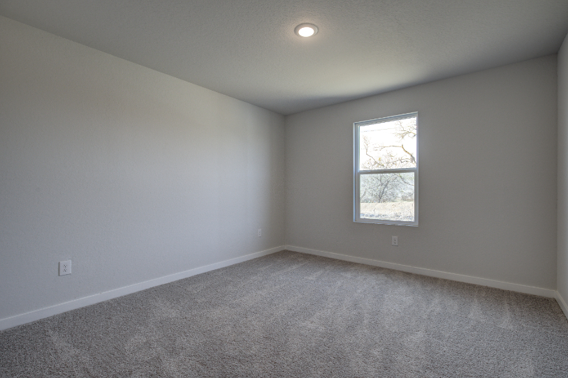 A room with a window and a carpet.
