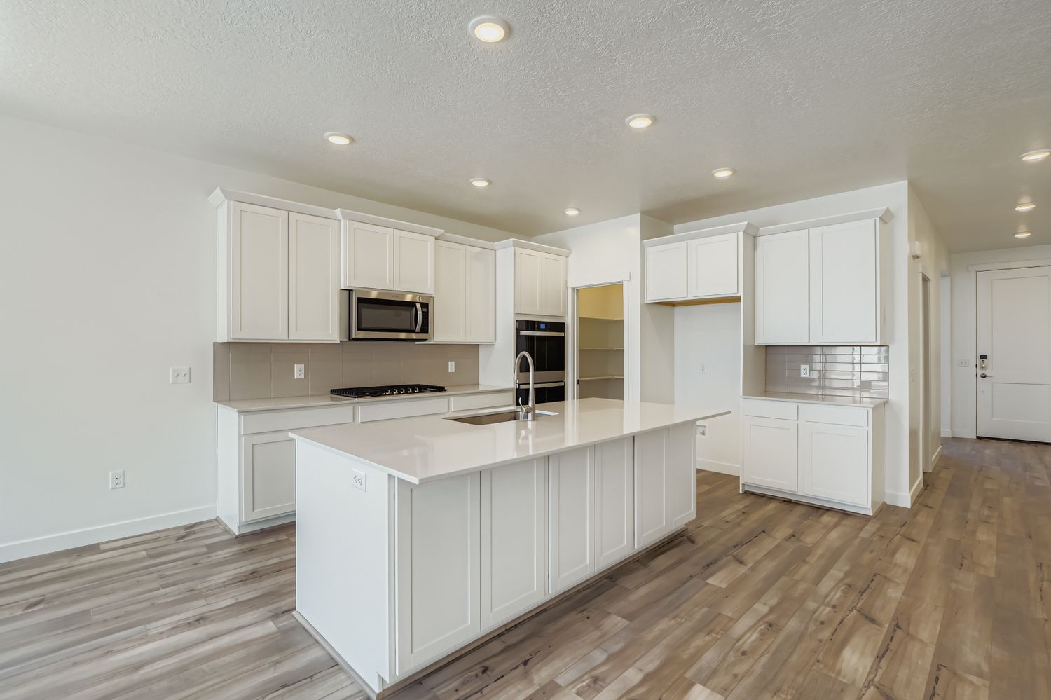 A kitchen with white cabinets.