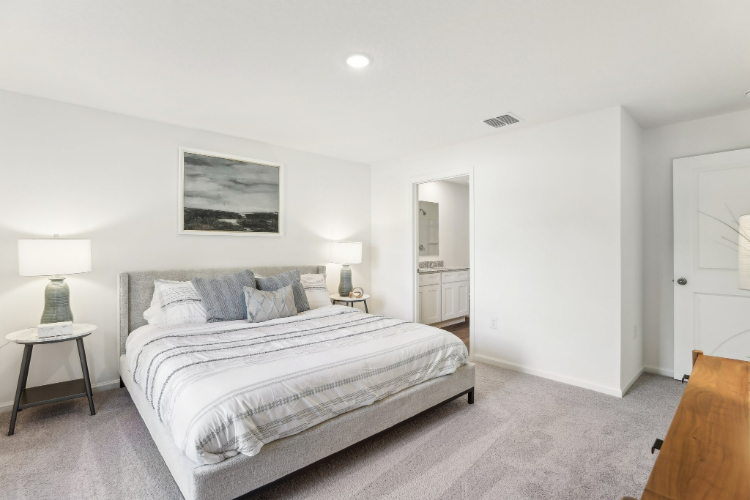 A bedroom with a bed and lamps.