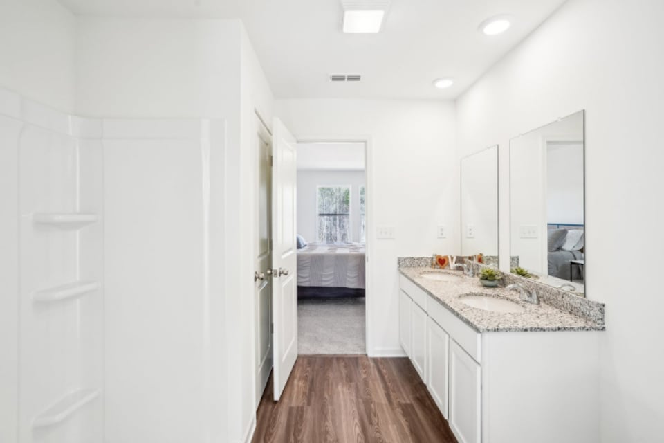 A bathroom with white cabinets.