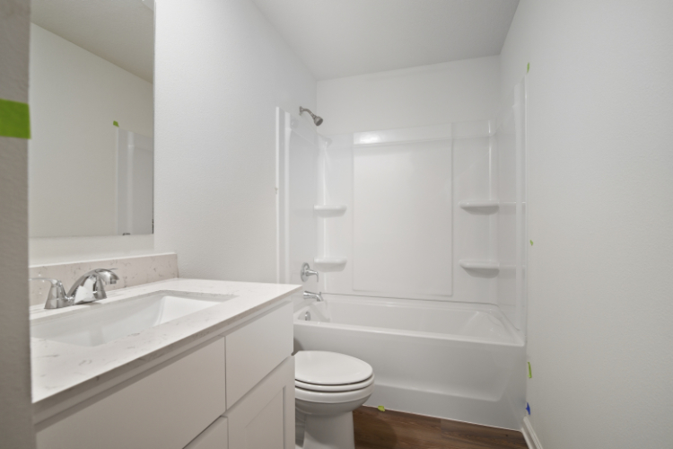 A bathroom with a tub sink and toilet.