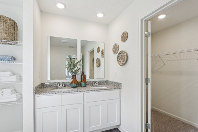 A bathroom with white cabinets.