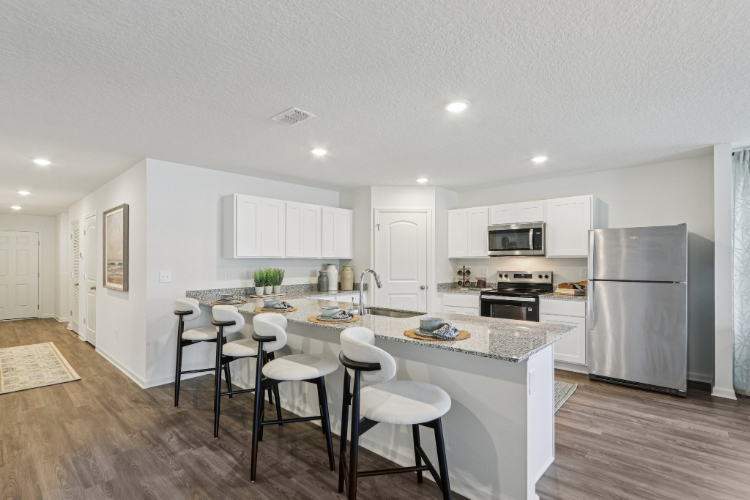 A kitchen with white cabinets.