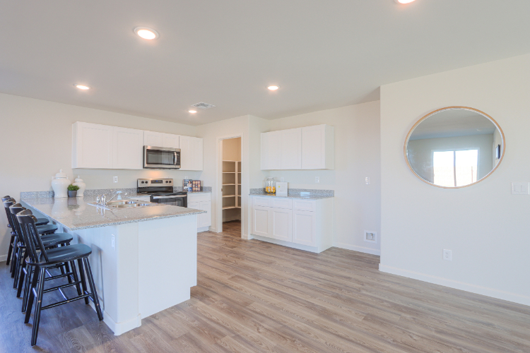 A kitchen with white cabinets.