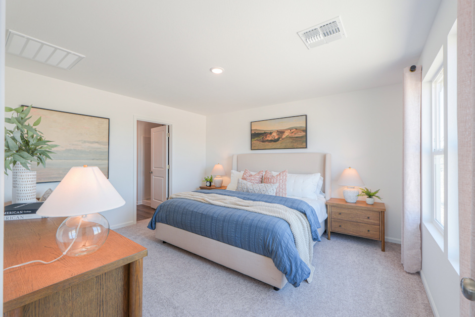 A bedroom with a bed and lamps.