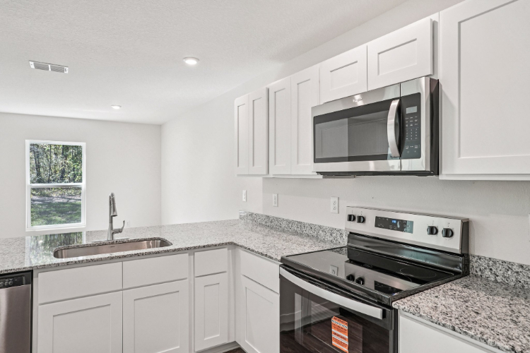 A kitchen with white cabinets.