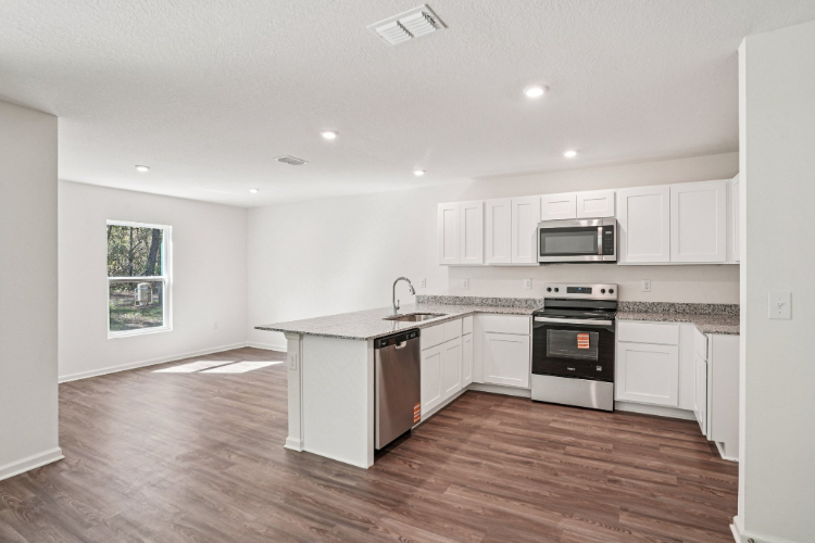 A kitchen with white cabinets.