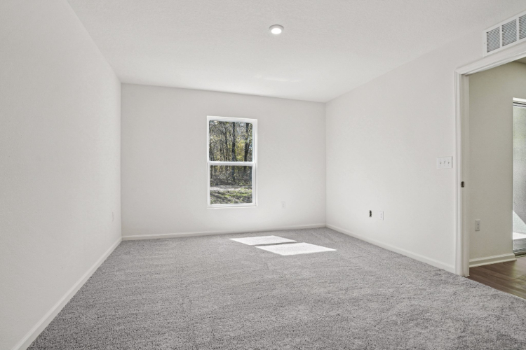 A room with a window and a carpet.