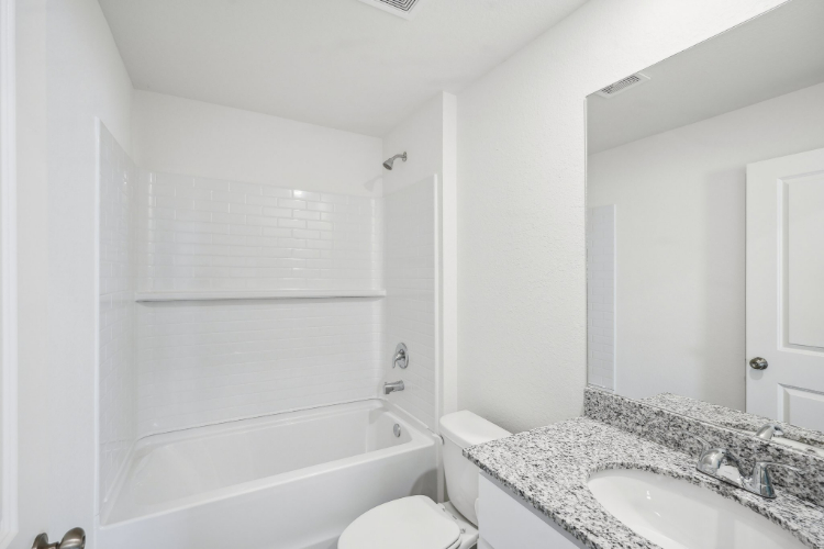 A bathroom with a tub sink and toilet.