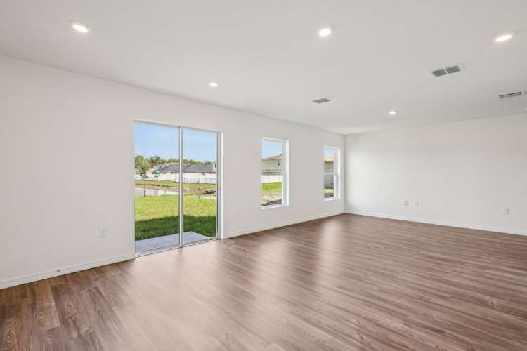 A room with a wood floor and windows.