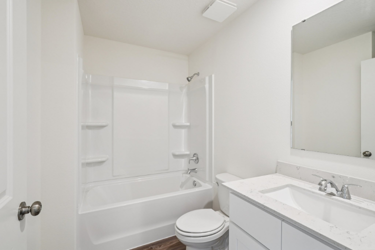 A bathroom with a tub sink and toilet.
